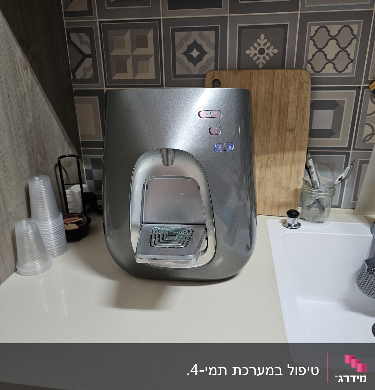 מכונת מים על השיש ליד כיור במטבח